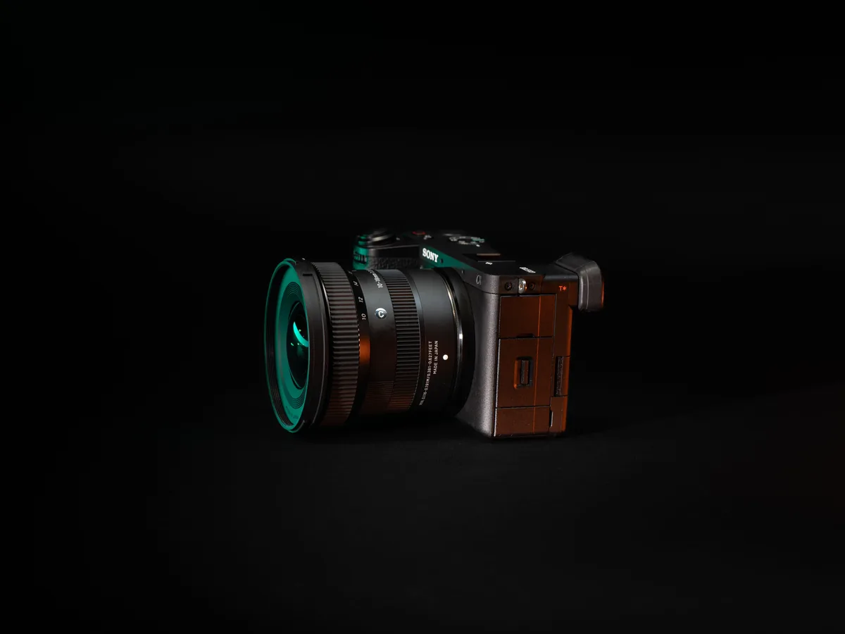 Real mirrorless camera and lens photographed on a black background